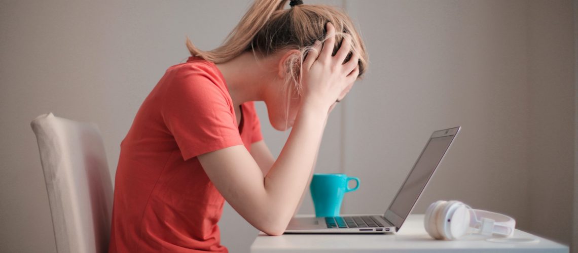 woman-in-red-t-shirt-looking-at-her-laptop-3755761